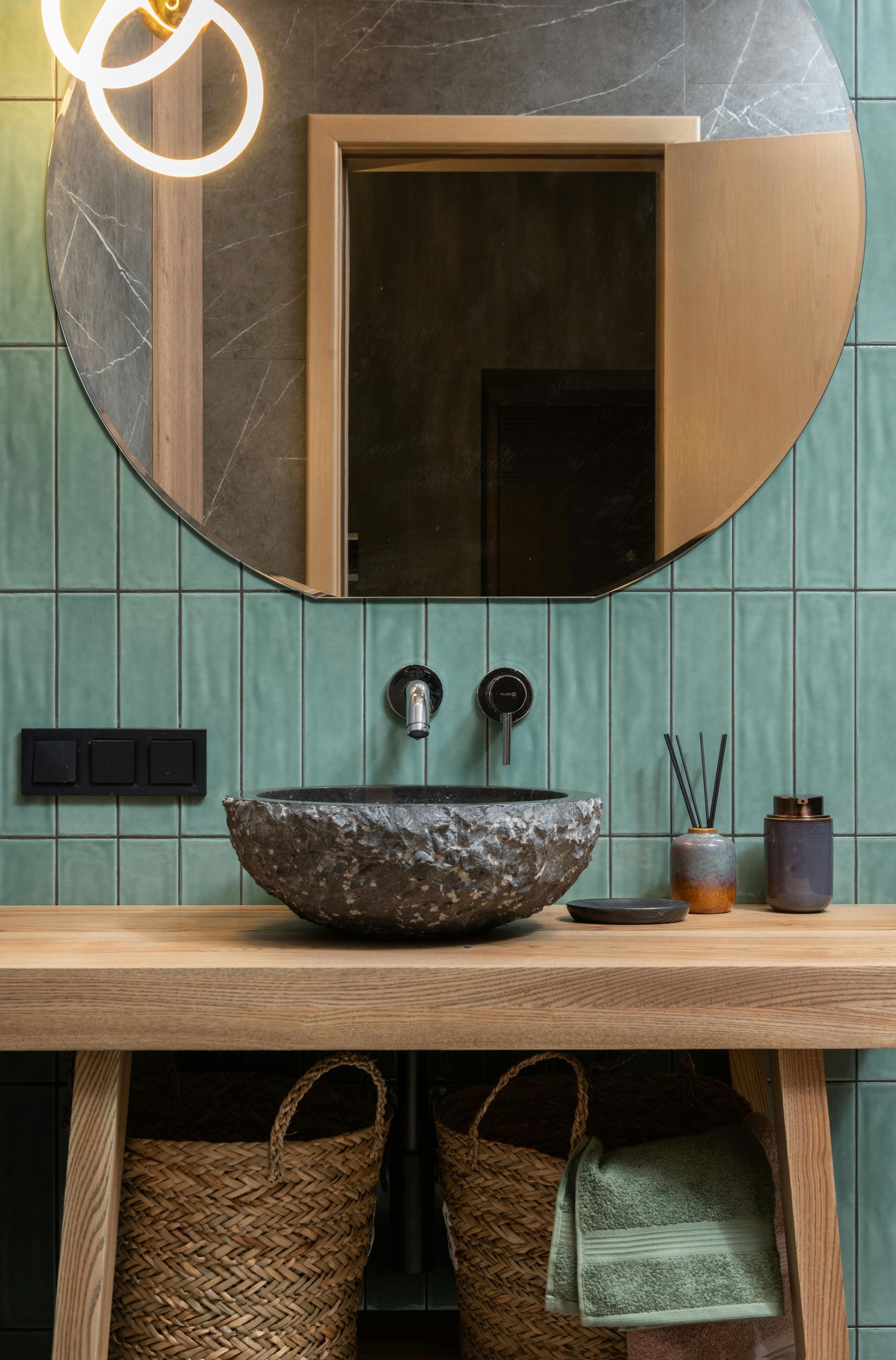 Bathroom with a round mirror, stone sink and green tiled wall — Lennox Build In Ballina, NSW