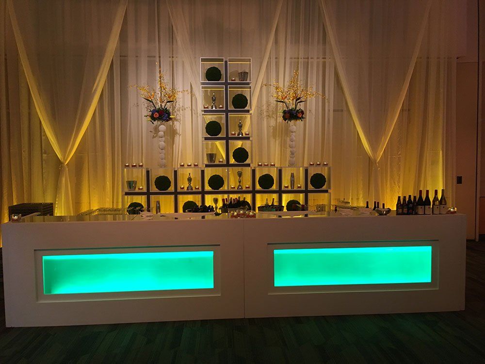 a bar with green lights and bottles on it
