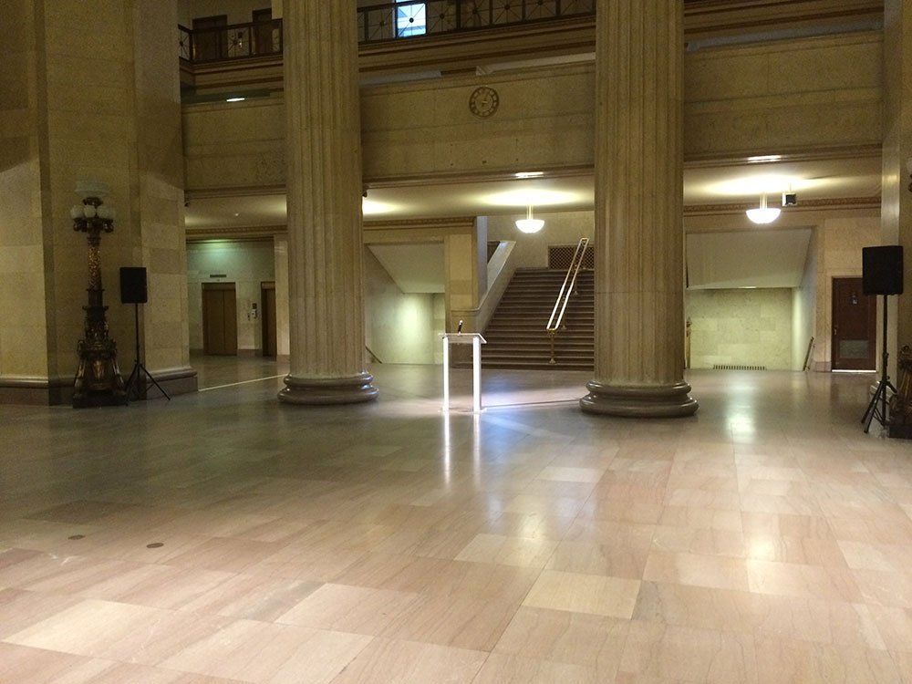 an empty lobby with columns and stairs and a podium in the middle