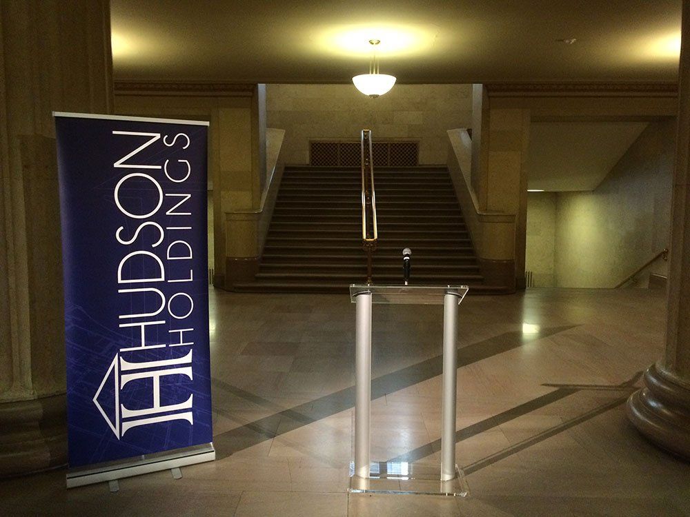 a podium in front of a sign that says hudson holdings