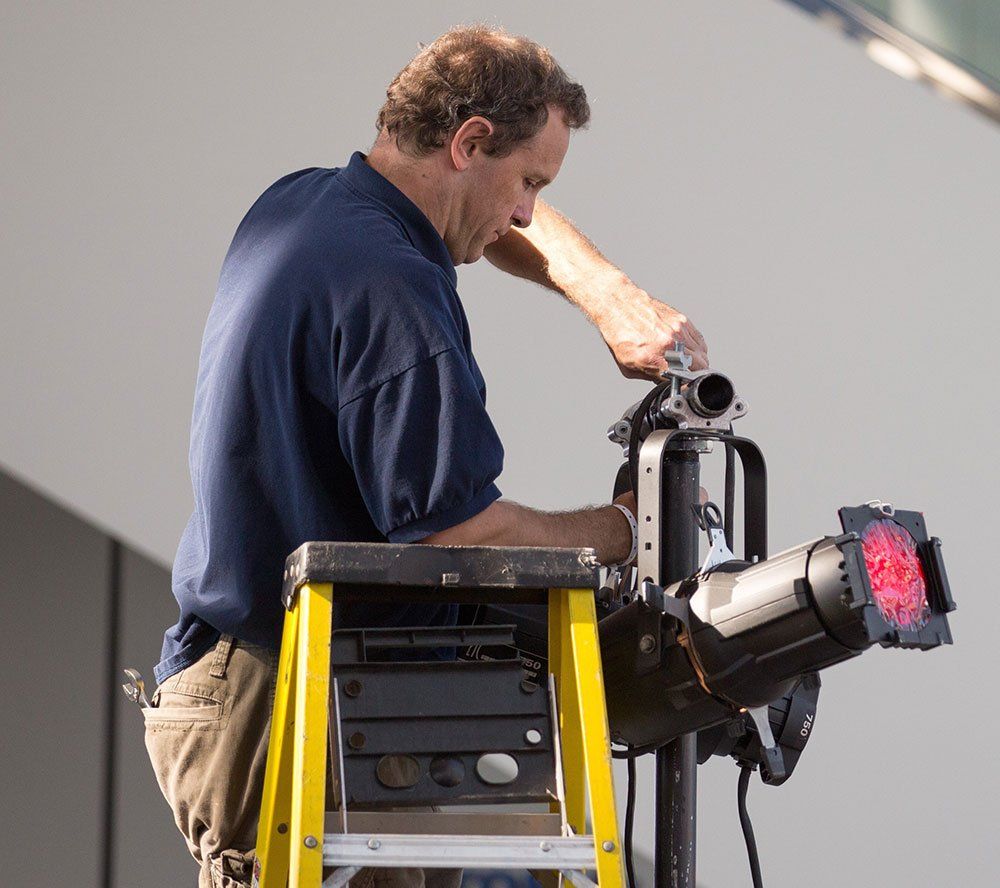 a man on a ladder working on a red light