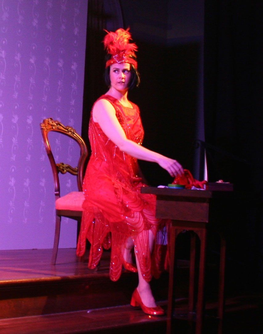 a woman in a red dress is sitting at a desk