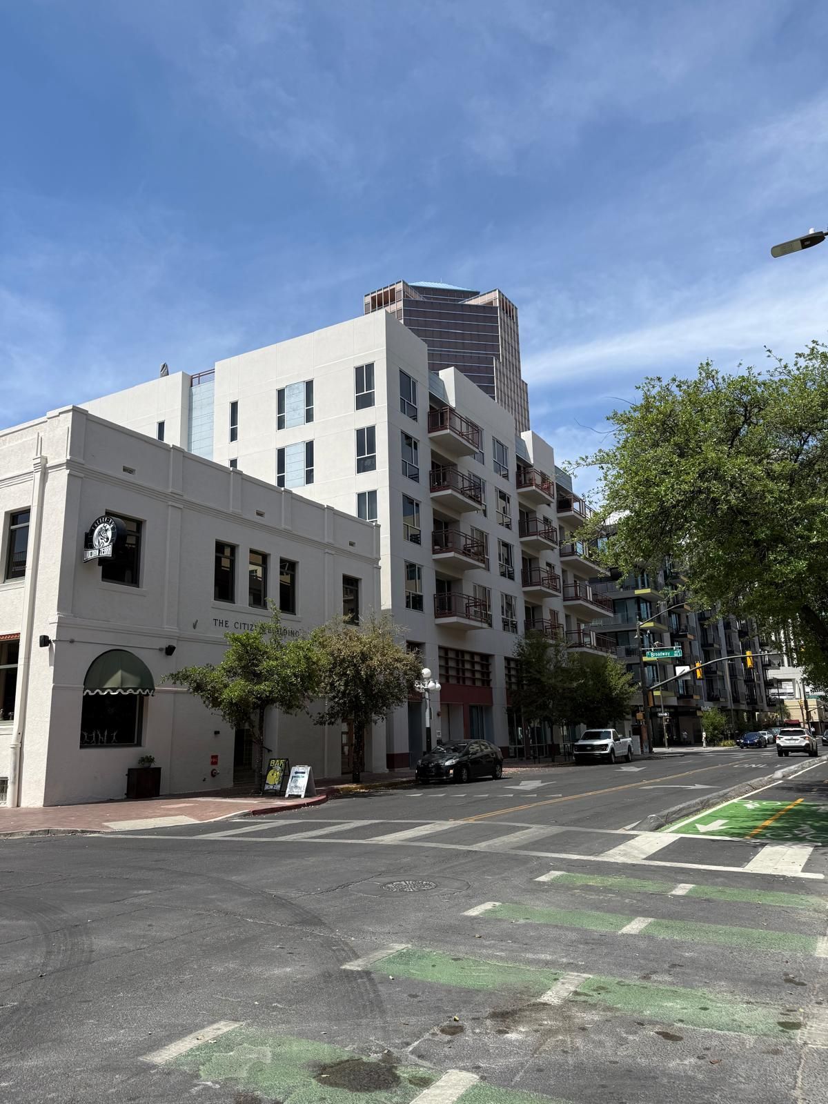 Street view of buildings, blue sky, and a bike lane.
