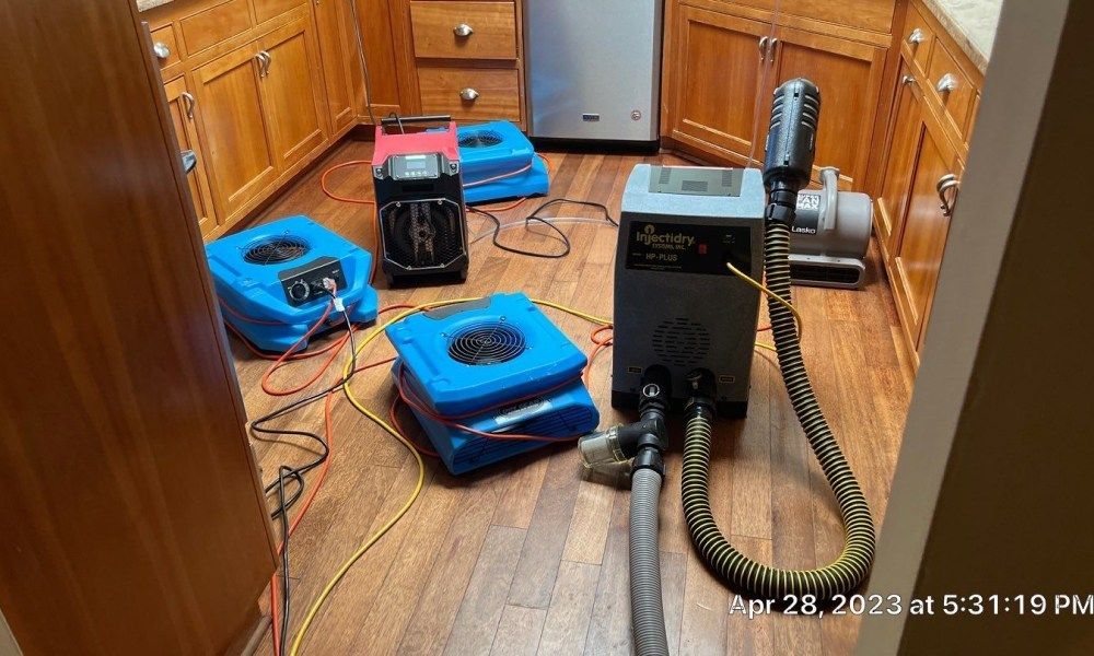 A kitchen with a lot of appliances on the floor.