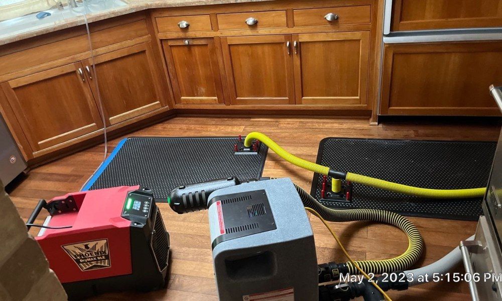A kitchen with wooden cabinets and a vacuum cleaner on the floor.
