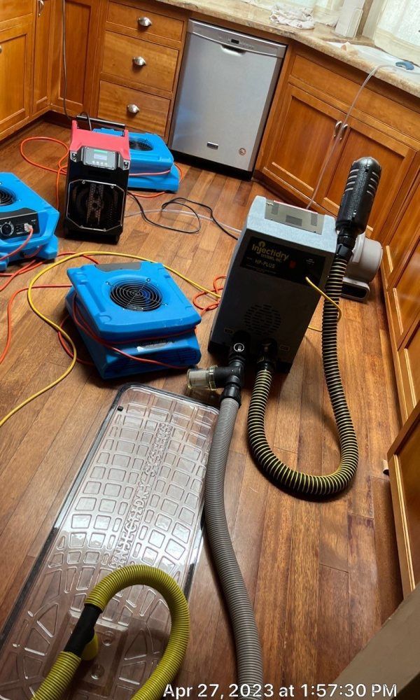 A kitchen with a lot of appliances on the floor.