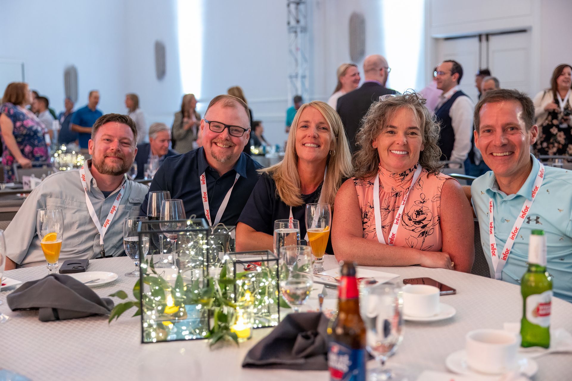 A happy group of people seated at a table smile at the camera