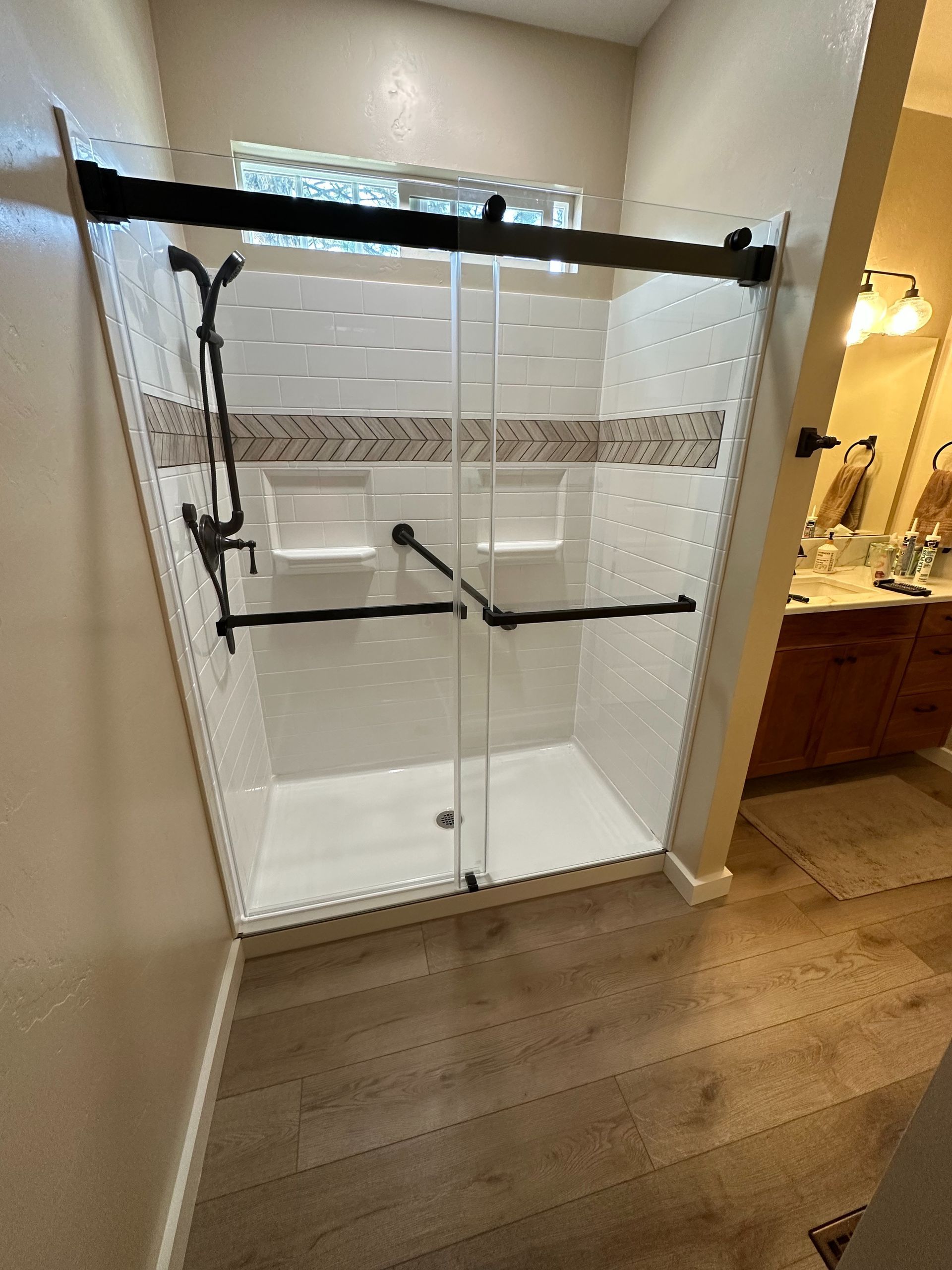 A bathroom with a walk in shower and a sink.
