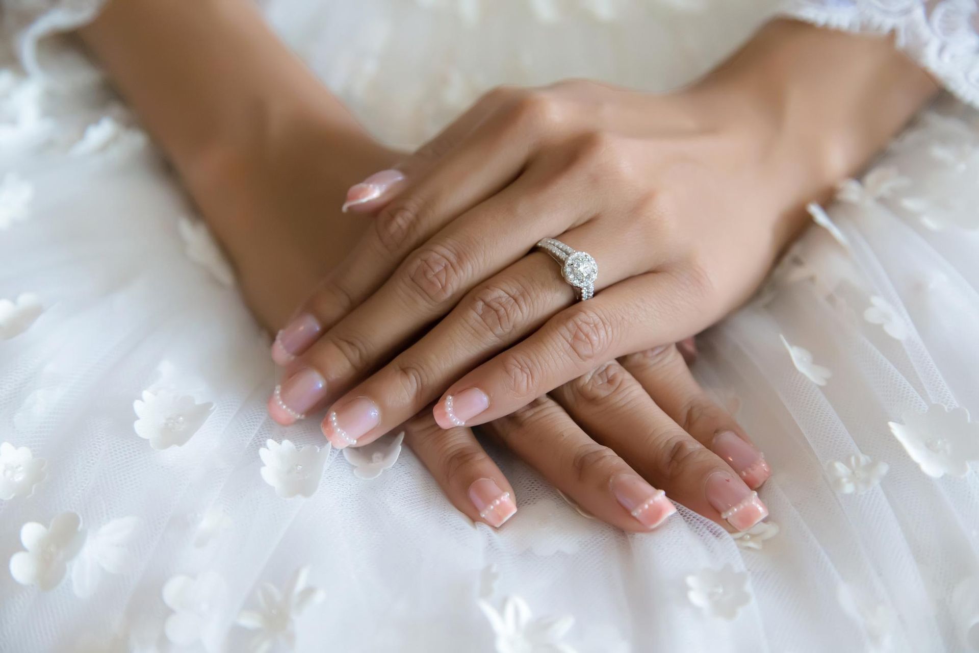 A close up of a woman 's hands with a wedding ring on her finger.