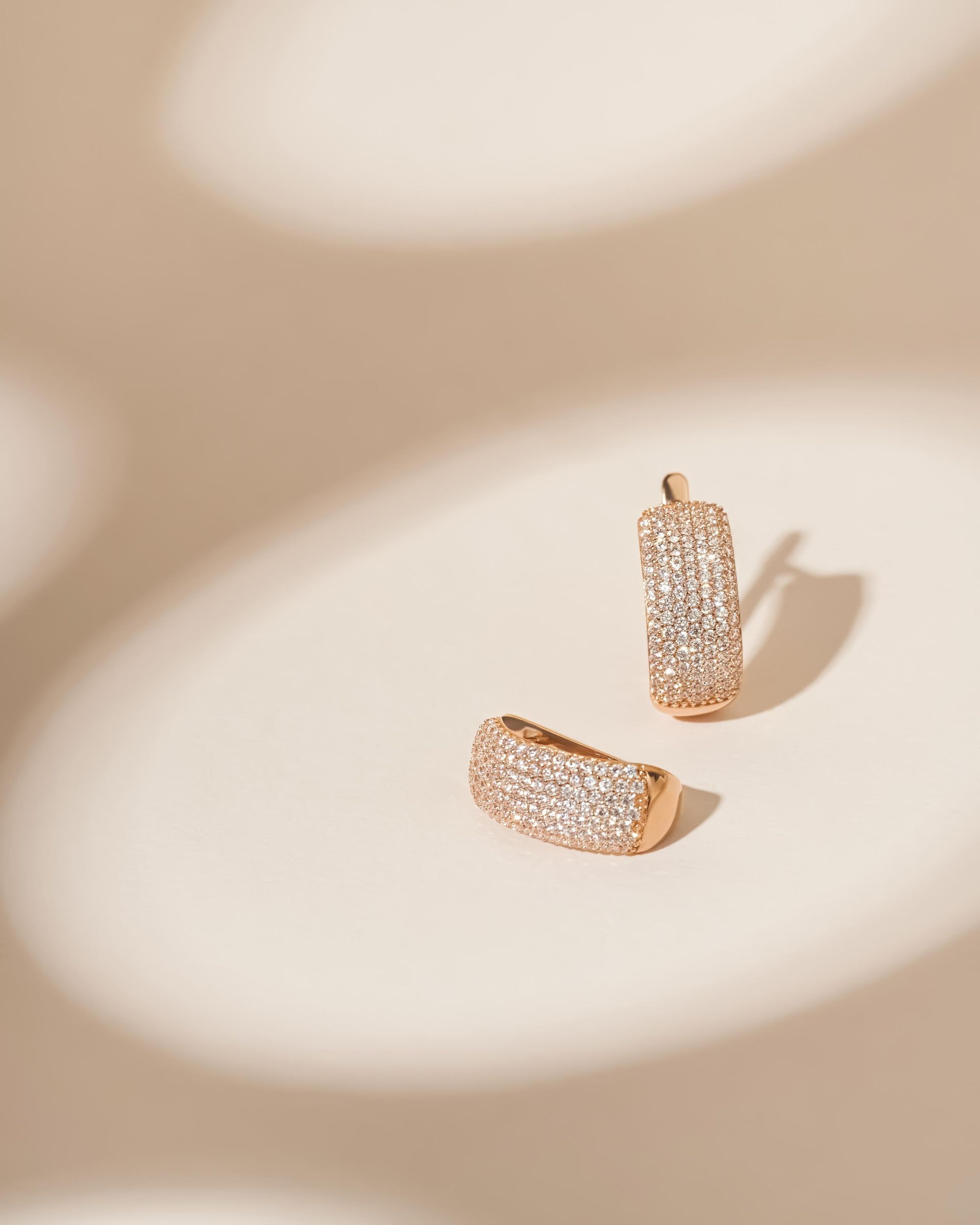 A pair of hoop earrings are sitting on a white surface.