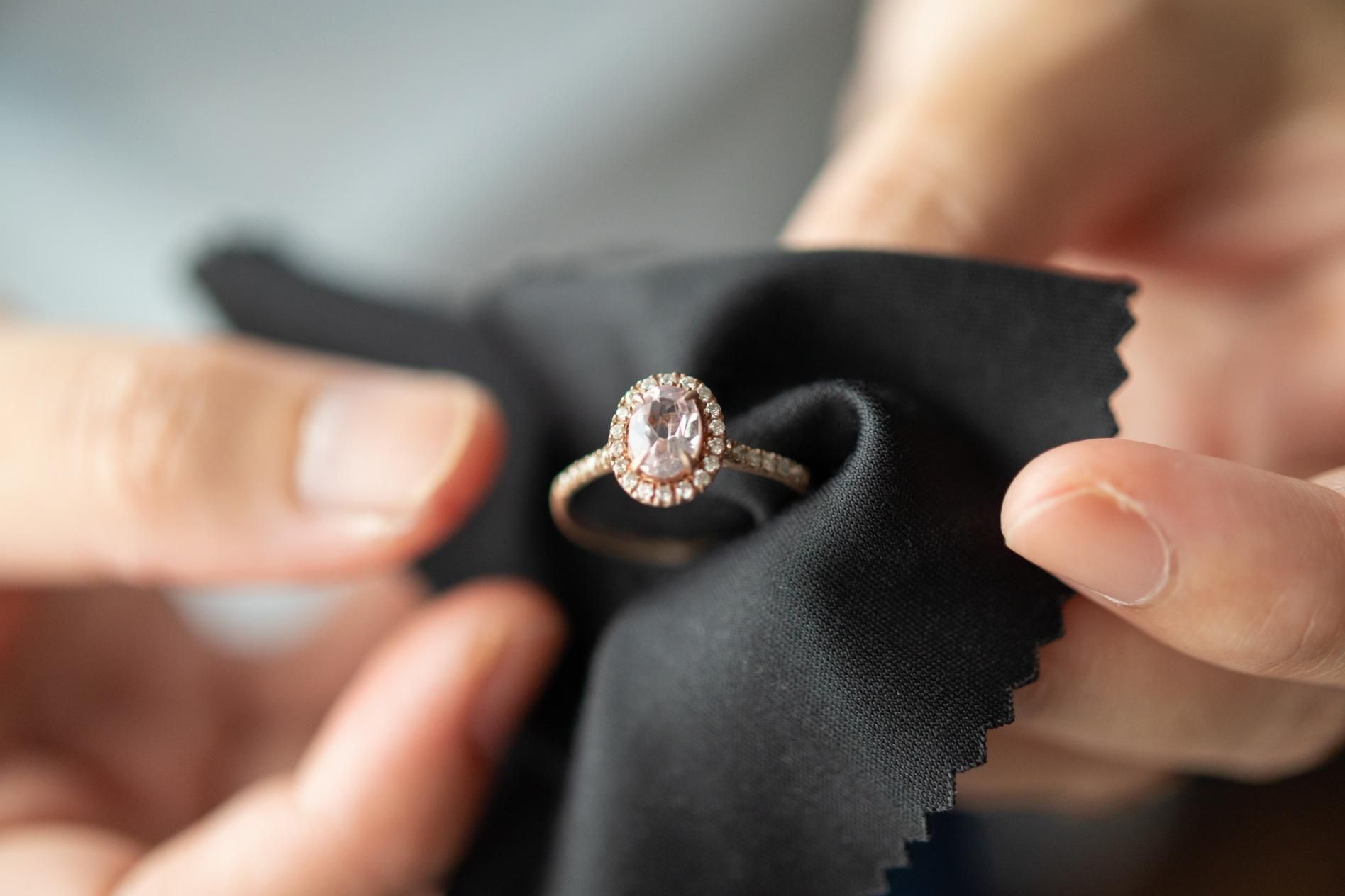 A person is cleaning a ring with a cloth.