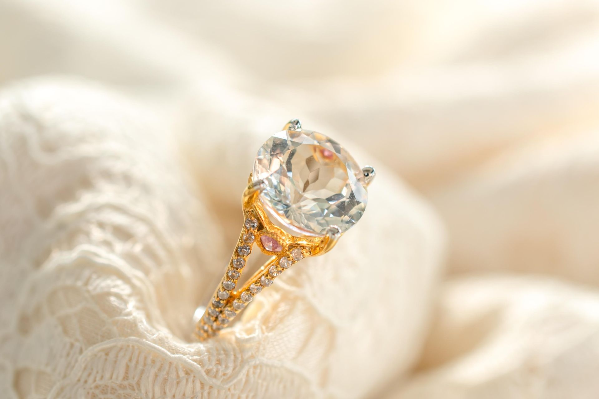 A close up of a diamond ring on a white cloth.