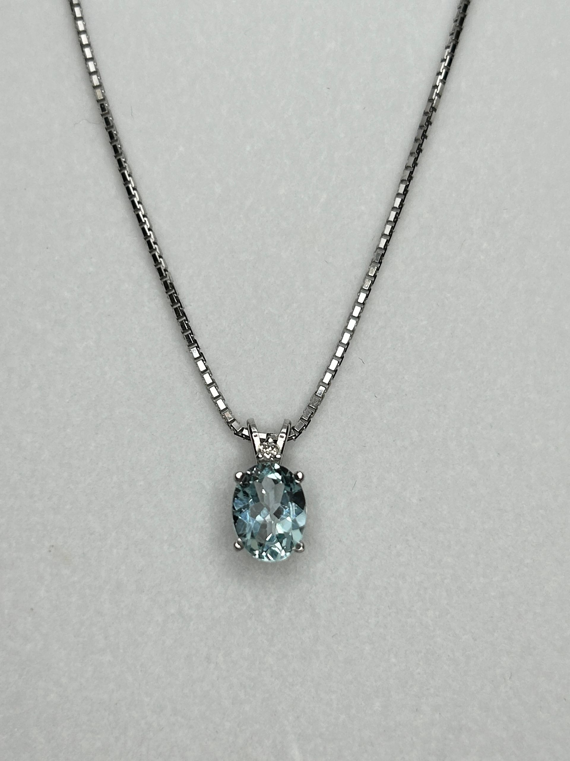 A necklace with a blue stone pendant on a chain.