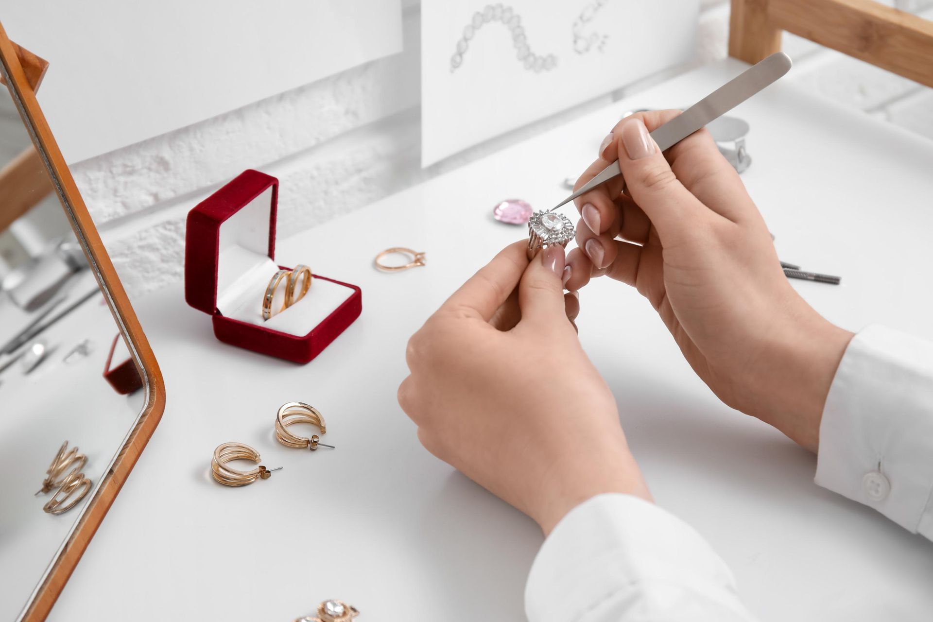 A woman is working on a ring at a table.