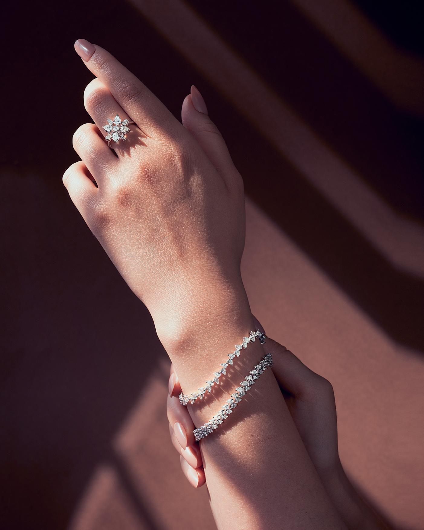 A woman wearing a ring and a bracelet on her wrist.