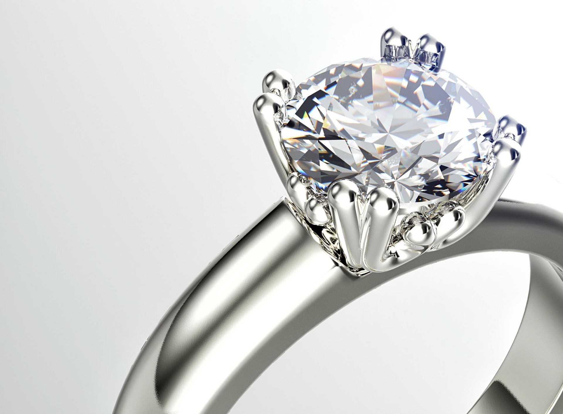 A close up of a diamond ring on a white background.