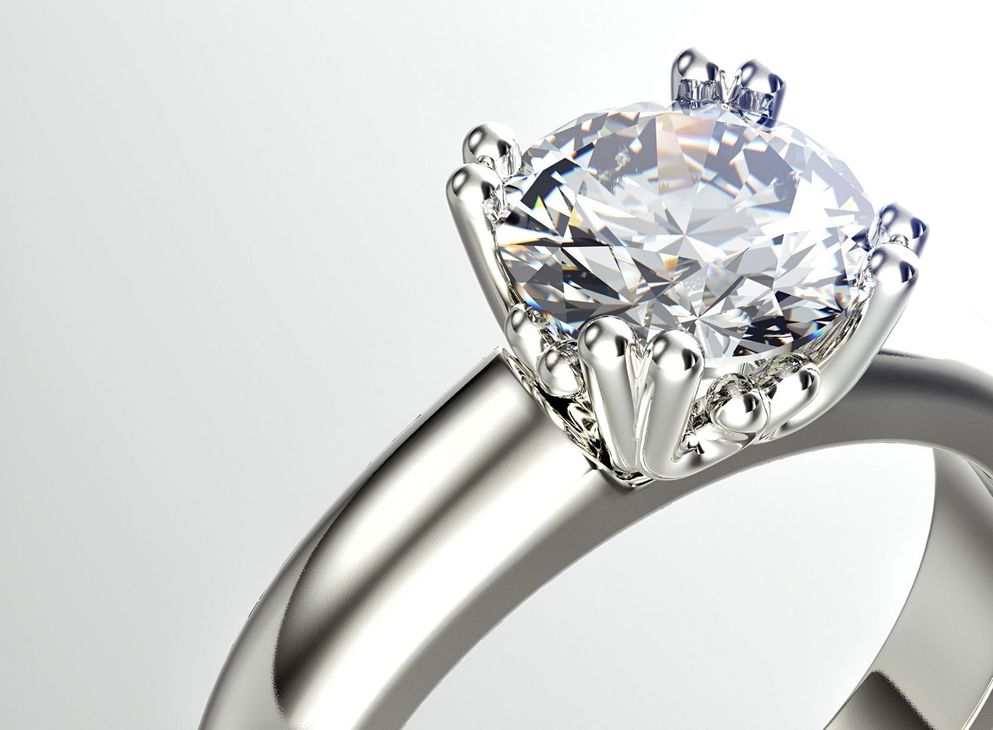 A close up of a diamond ring on a white background.