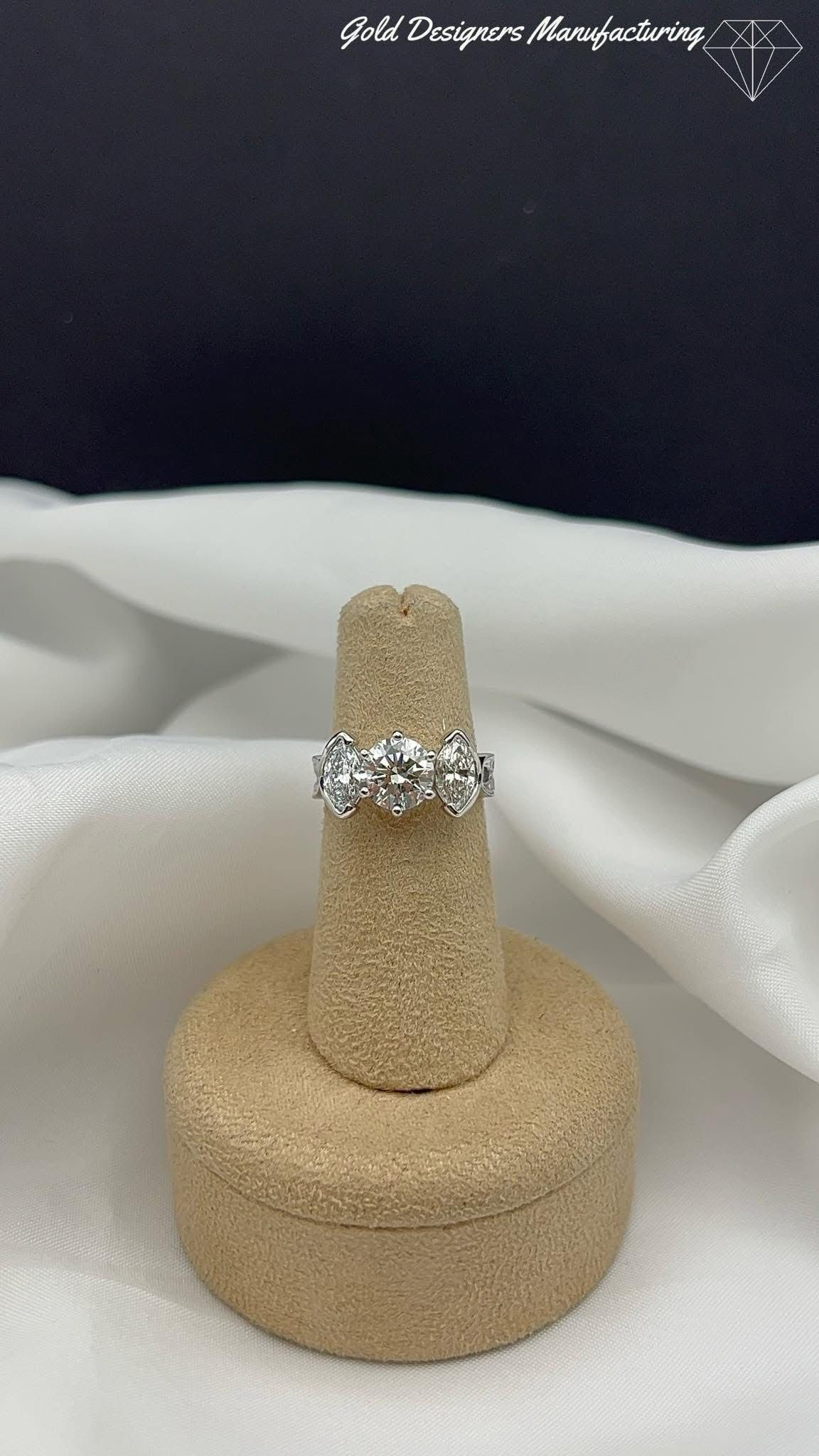 Custom made diamond engagement ring with half bezel set marquises.