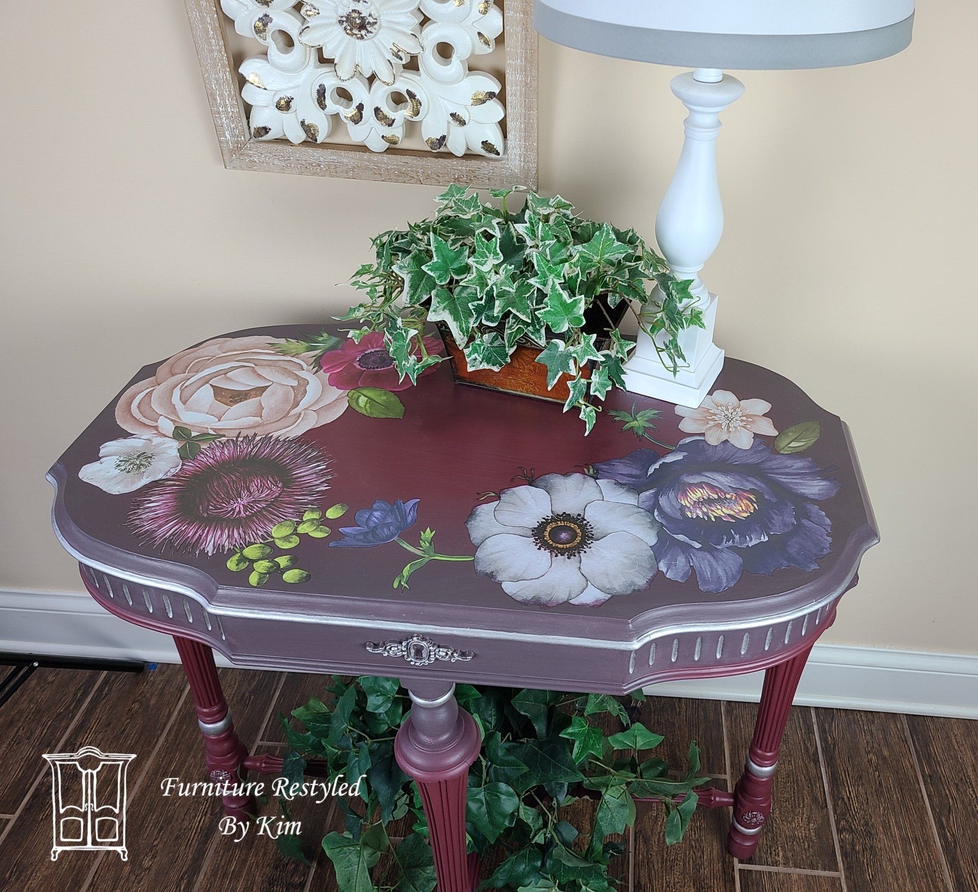 Cranberry Console Table with floral paintings and ornamental plants on top and under