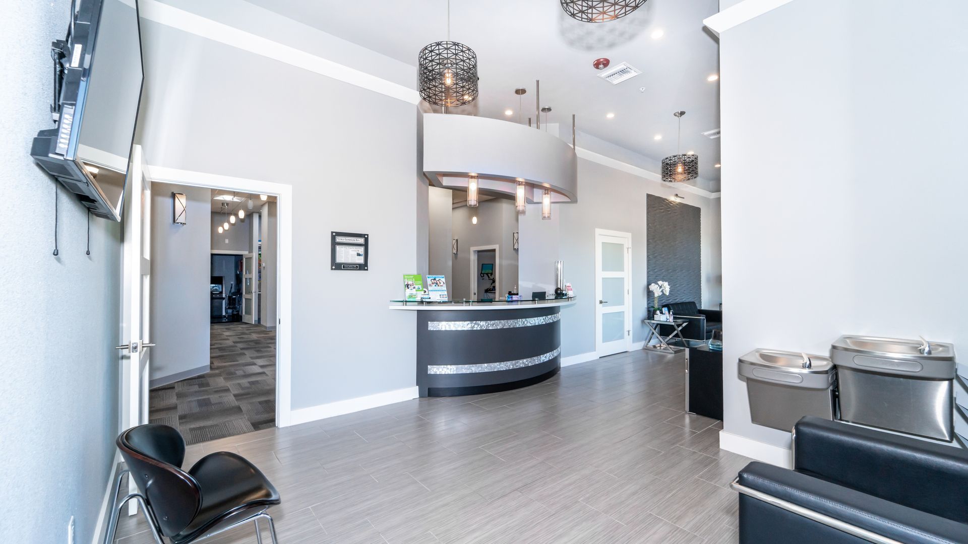 A large waiting room with a reception desk and chairs.