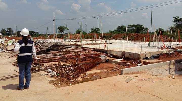 Una mujer con casco está parada en un sitio de construcción.