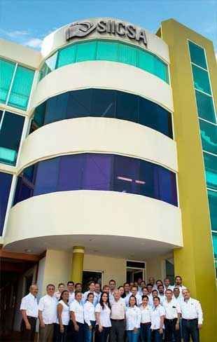 Un grupo de personas posan para una fotografía frente a un gran edificio.