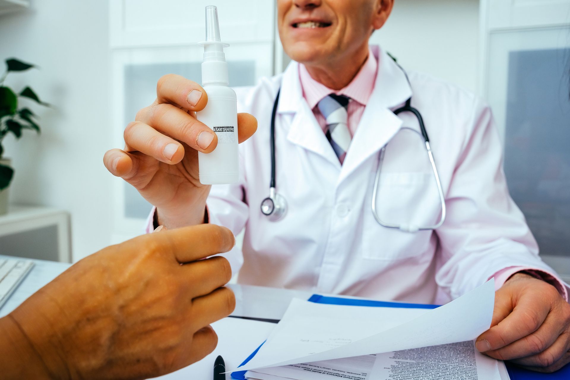 Doctor handing a nasal spray to a patient, medical setting.