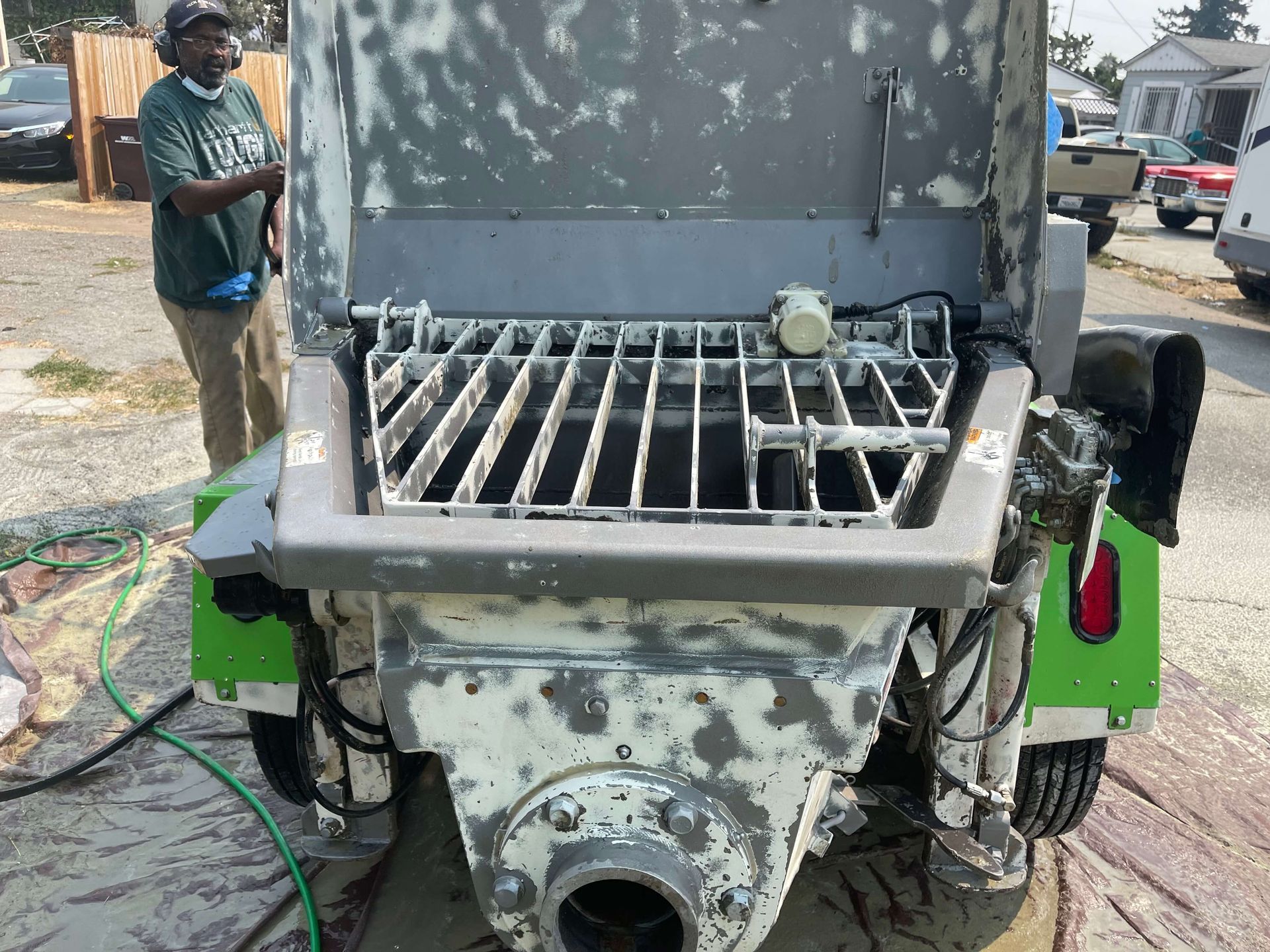 A man is standing next to a concrete pump on a trailer.
