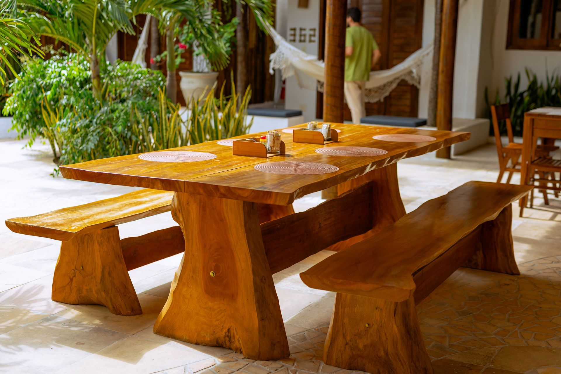 Interior de restaurante com mesas e cadeiras de madeira, mural de cavalos e lustres decorativos.