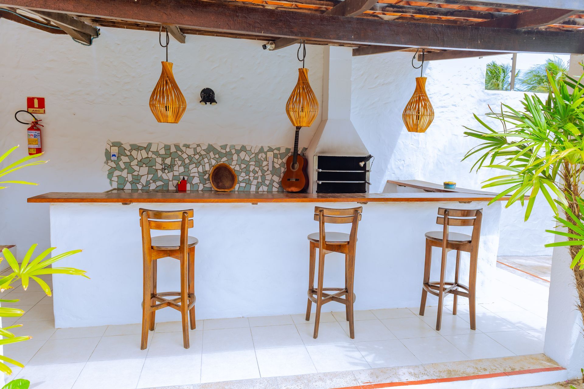 Estrutura de madeira para parque infantil com escorregadores e balanços em um gramado.