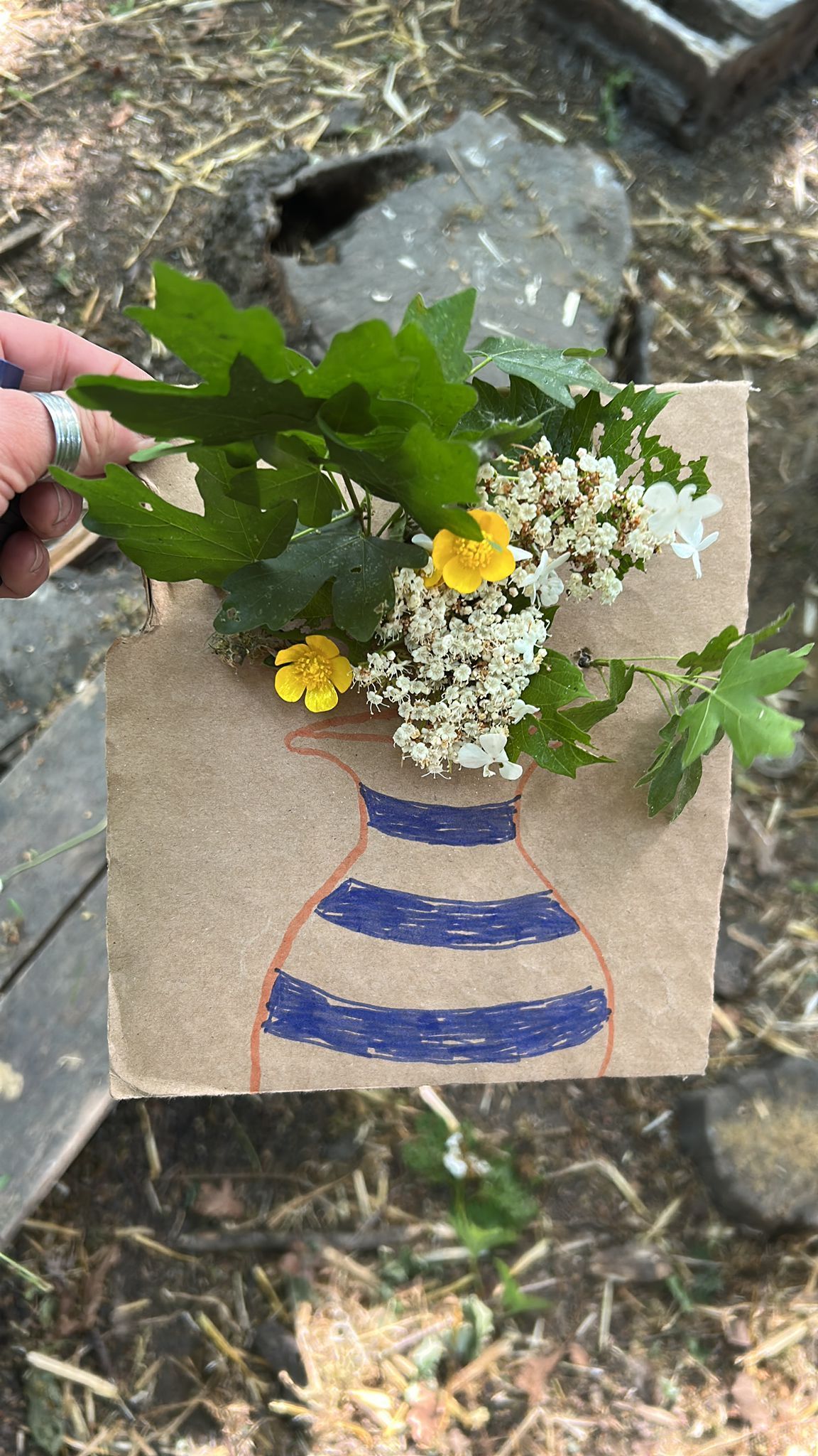 Brown paper with vase drawing, fresh flowers and leaves.