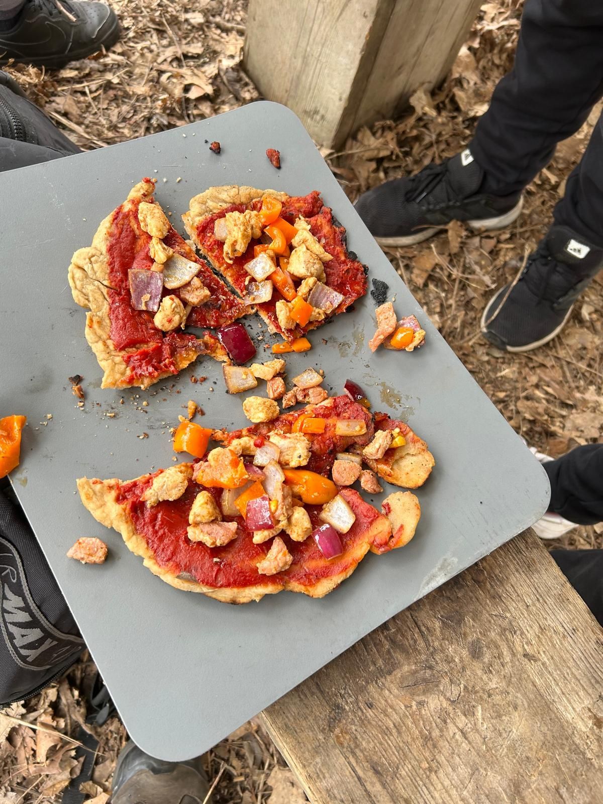 Two pieces of pizza are sitting on a cutting board.