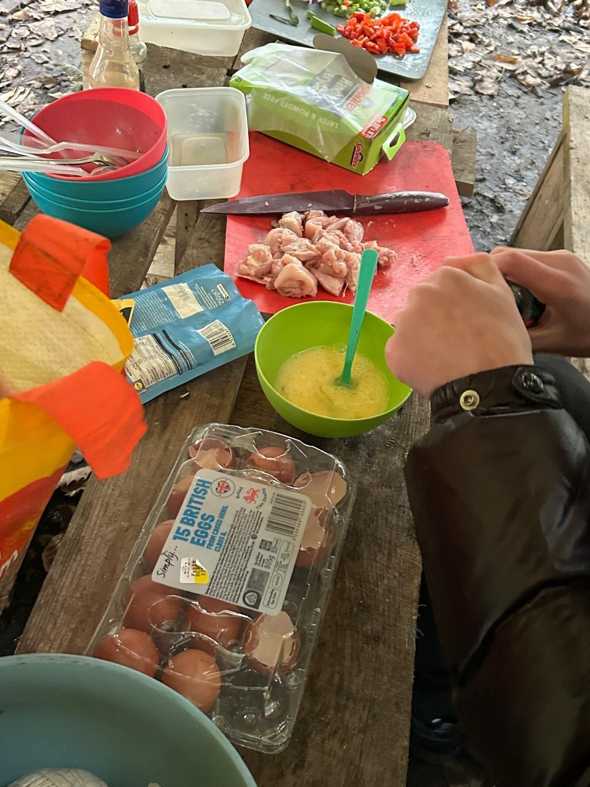 A person is preparing food on a wooden table.