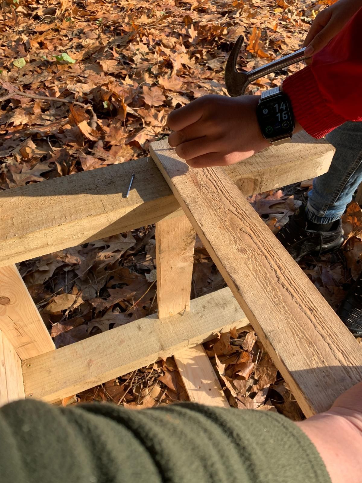 A person is hammering a nail into a piece of wood.