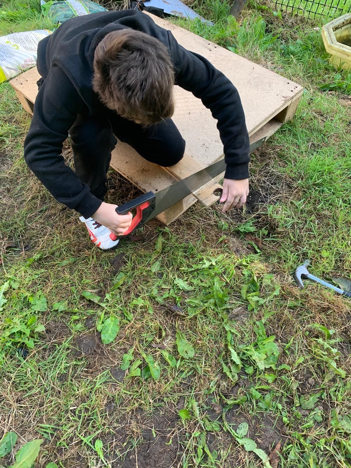 A man is cutting a piece of wood with a saw.