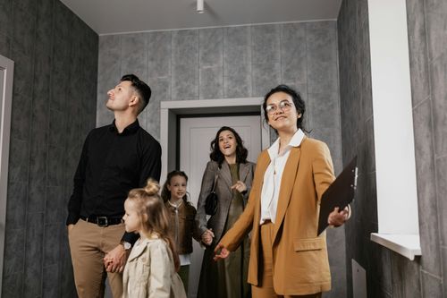 Family and realtor in an apartment hallway