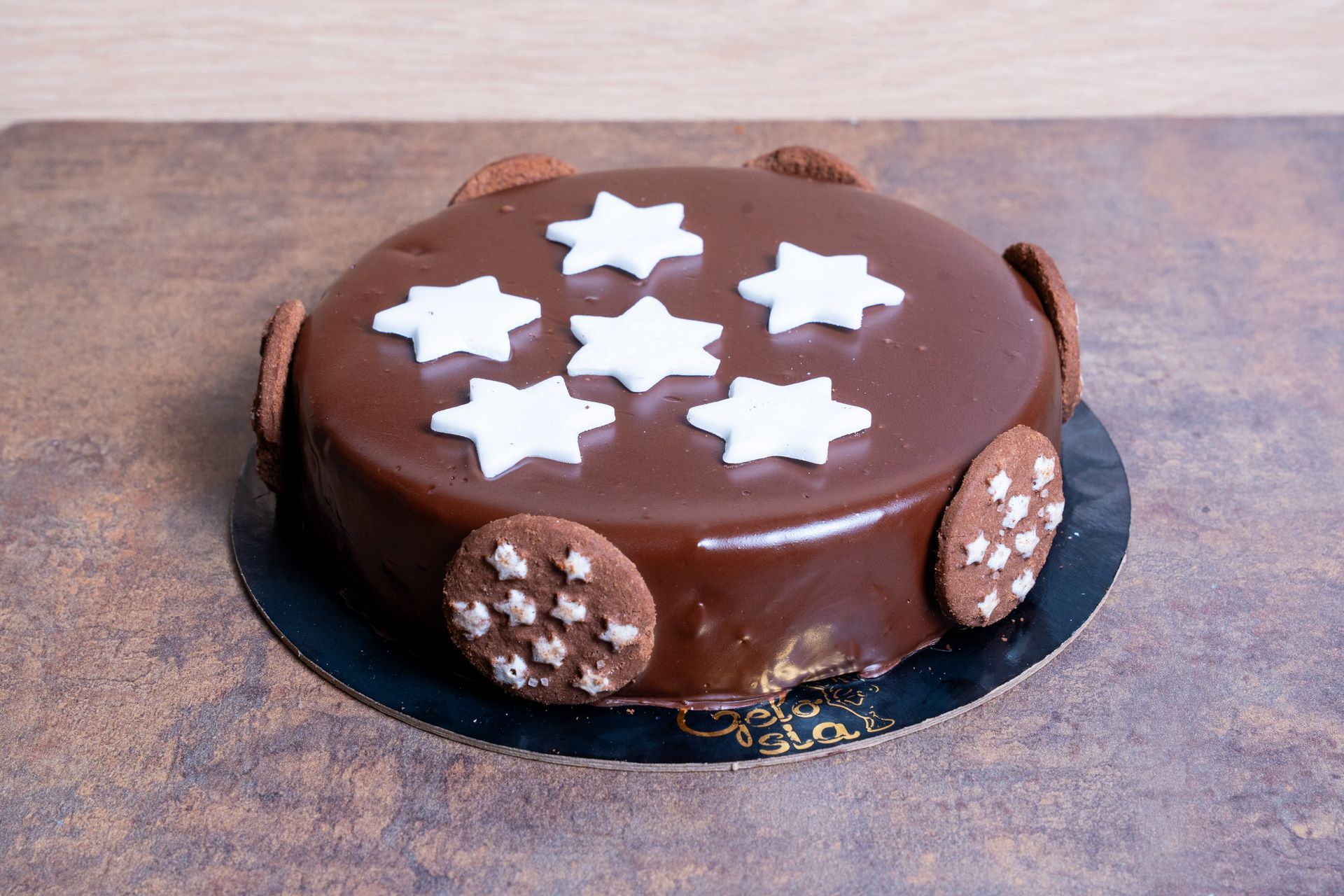 Torta al cioccolato con decorazioni a stella bianca su un piatto nero