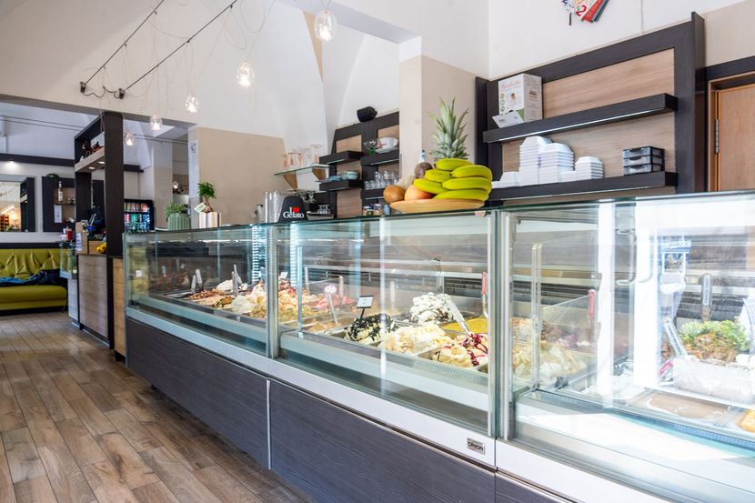 Vetrine espositive moderne per pasticceria, con torte e pasticcini all'interno, in un ambiente luminoso.