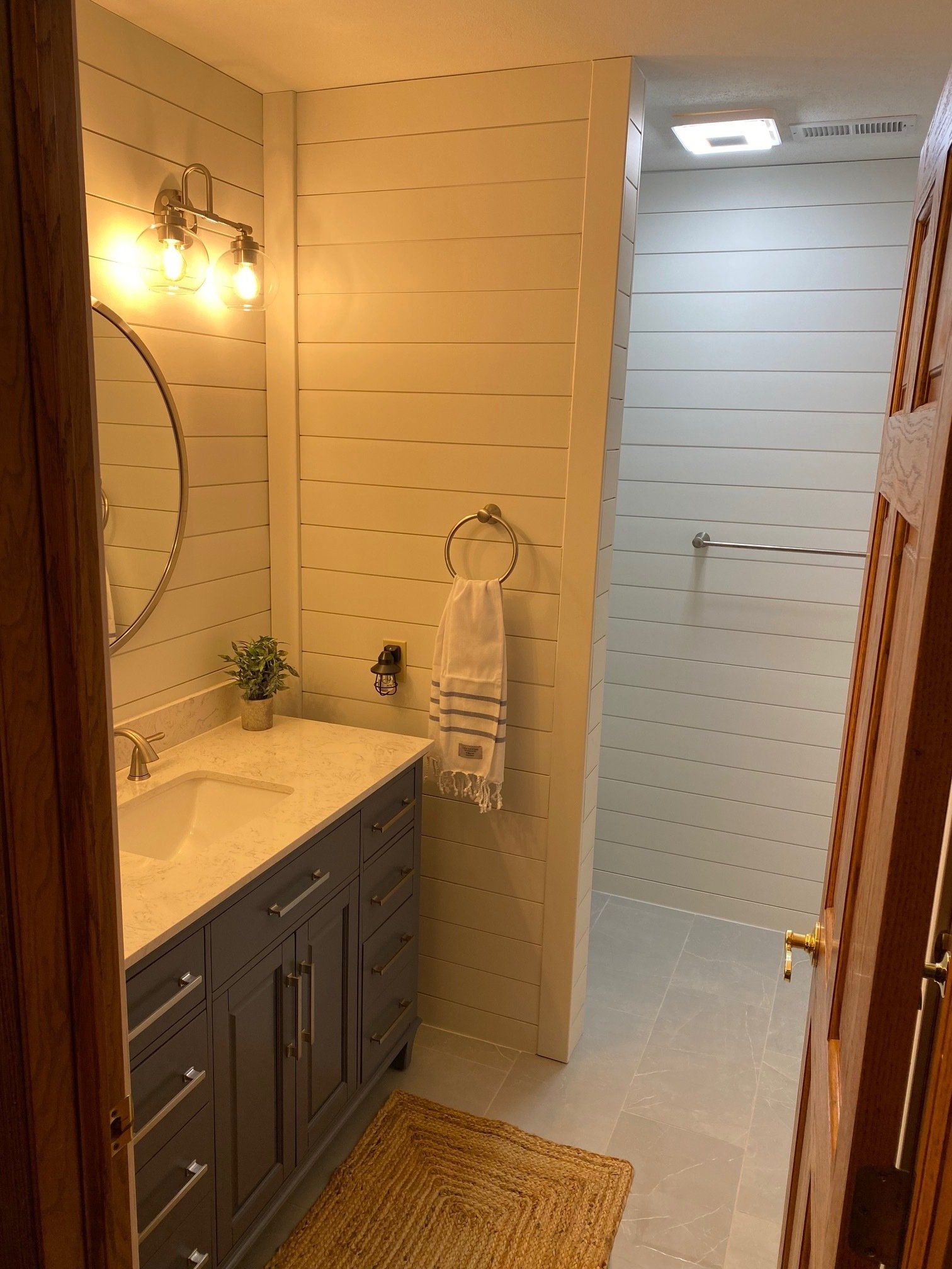 Shiplap bathroom remodel with smooth grey porcelain tile floors