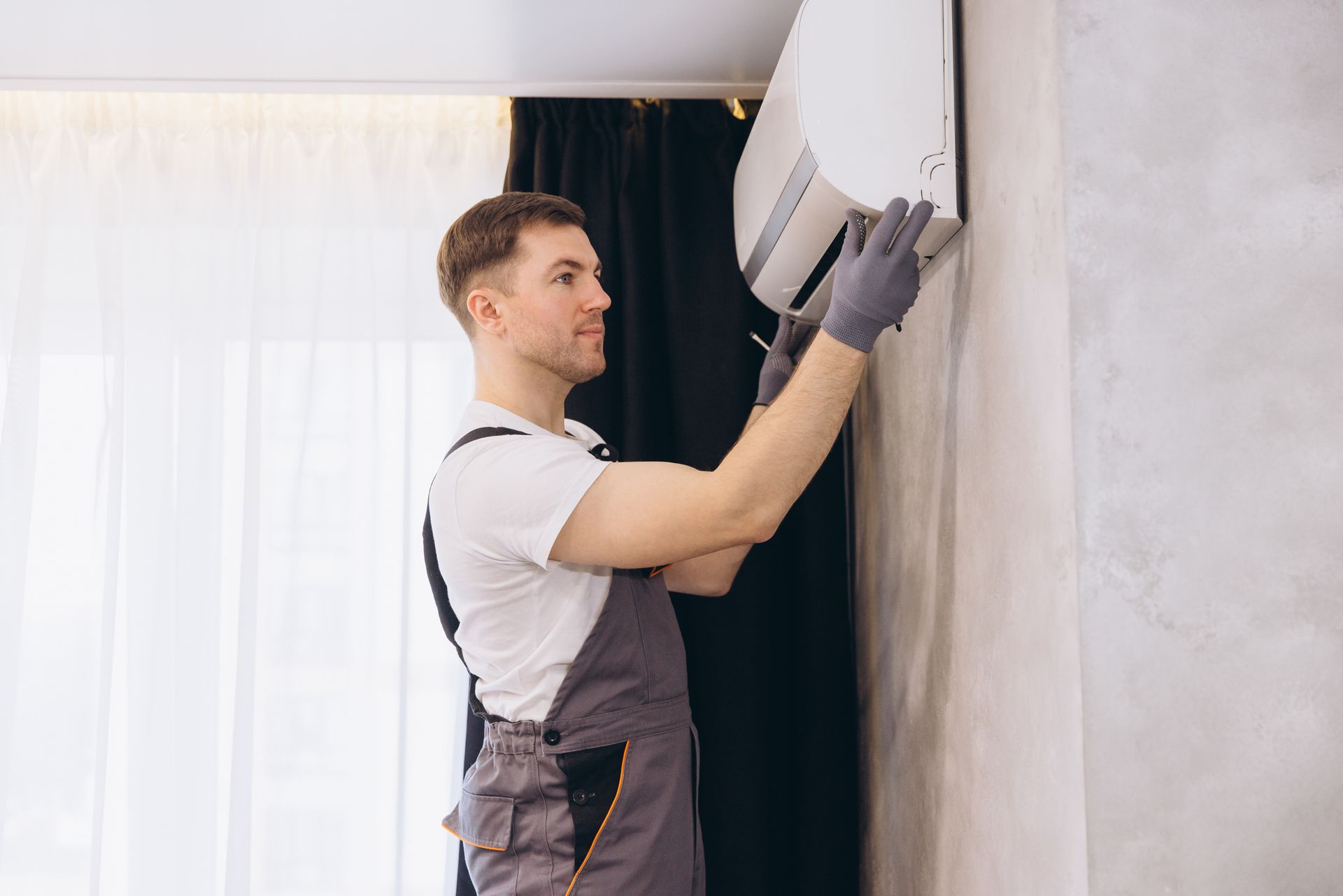 Technician repairing a modern air conditioner unit indoors, providing expert AC repair service. Technician repairing a modern air conditioner unit indoors, providing expert AC repair service.