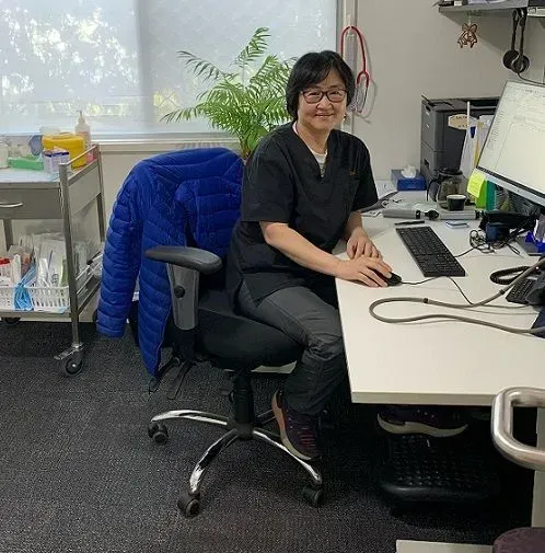 A woman is sitting at a desk in front of a computer. A woman is sitting at a desk in front of a computer.