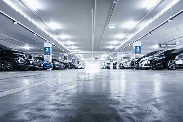 Empty city street with multistory buildings on both sides, sunny day.