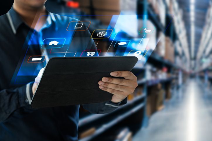 Modern high-rise apartment building against a bright blue sky, with balconies and tan brickwork.