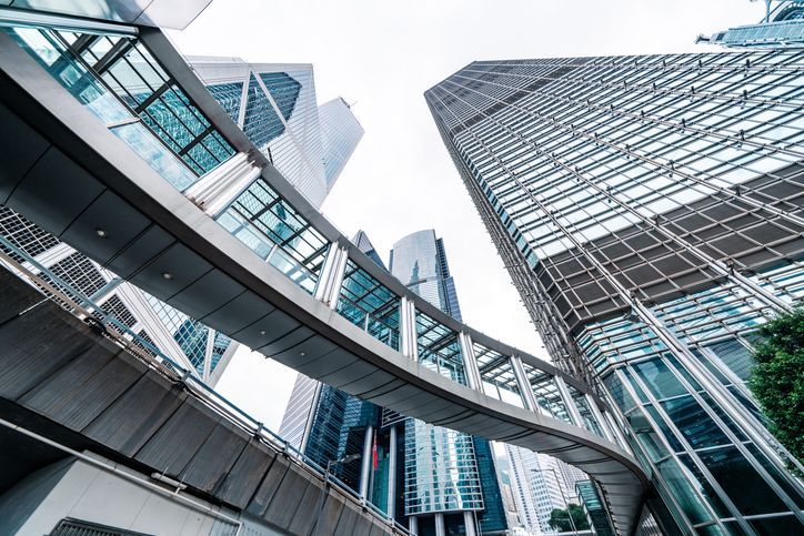Construction worker in neon yellow shirt, reviewing blueprints at a construction site.