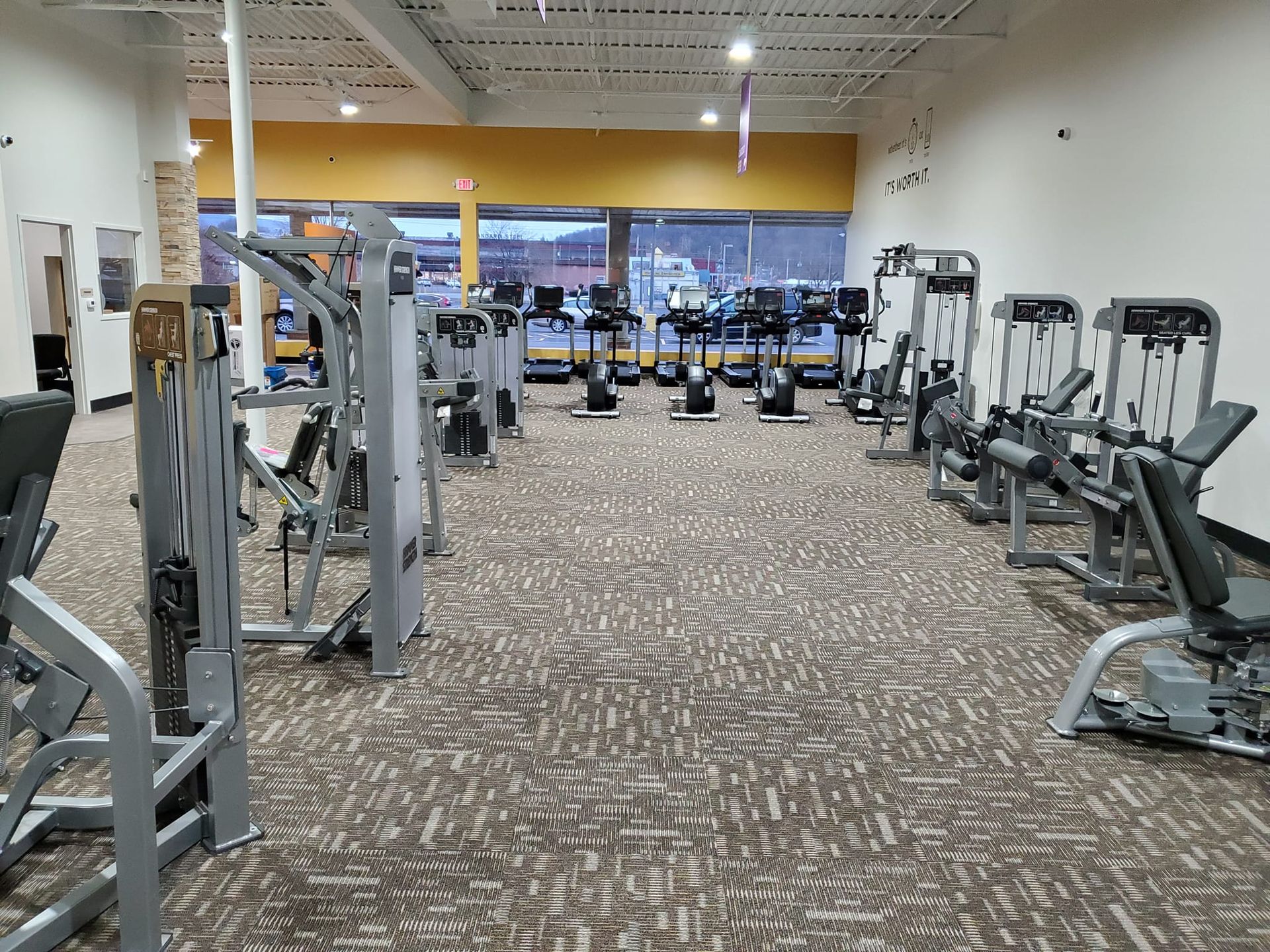 A large gym filled with lots of exercise equipment.