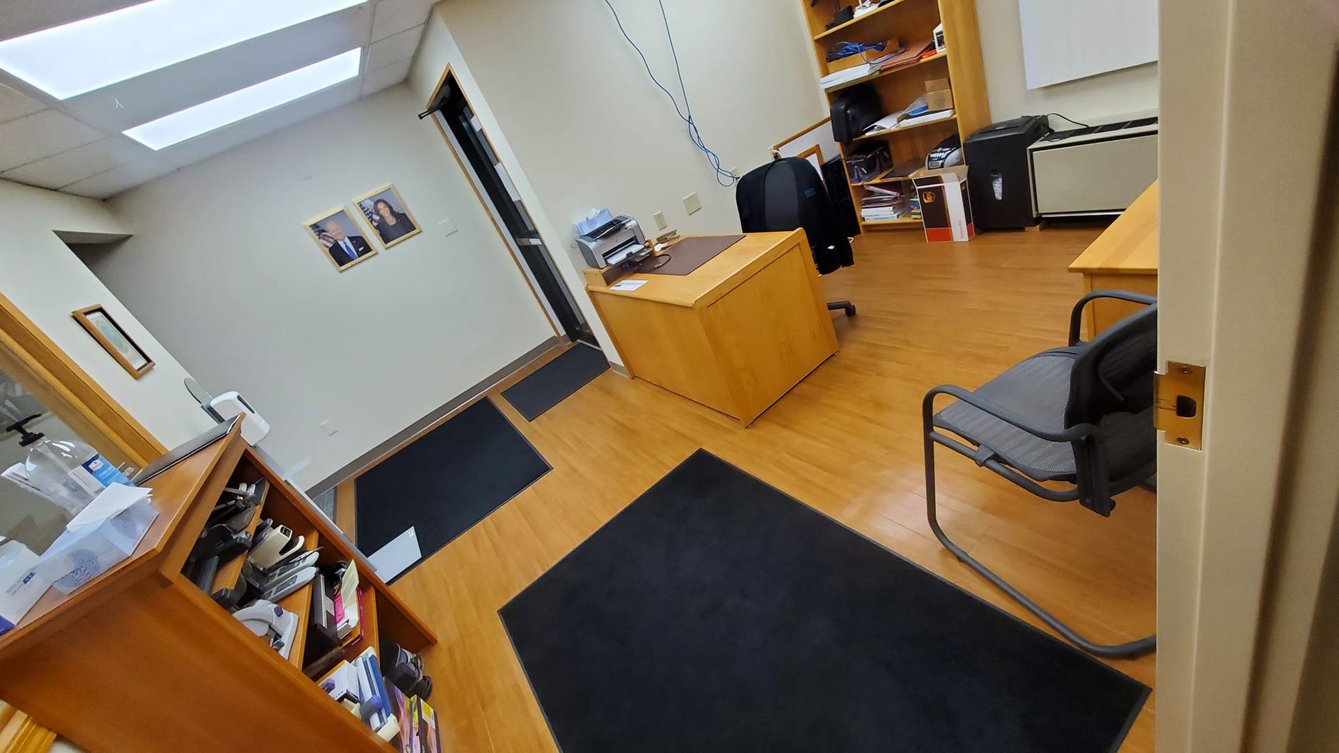 A room with a desk , chair , bookshelf and rug.
