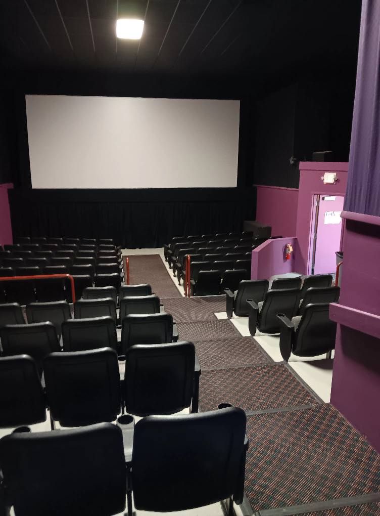 An auditorium with rows of seats and a large screen