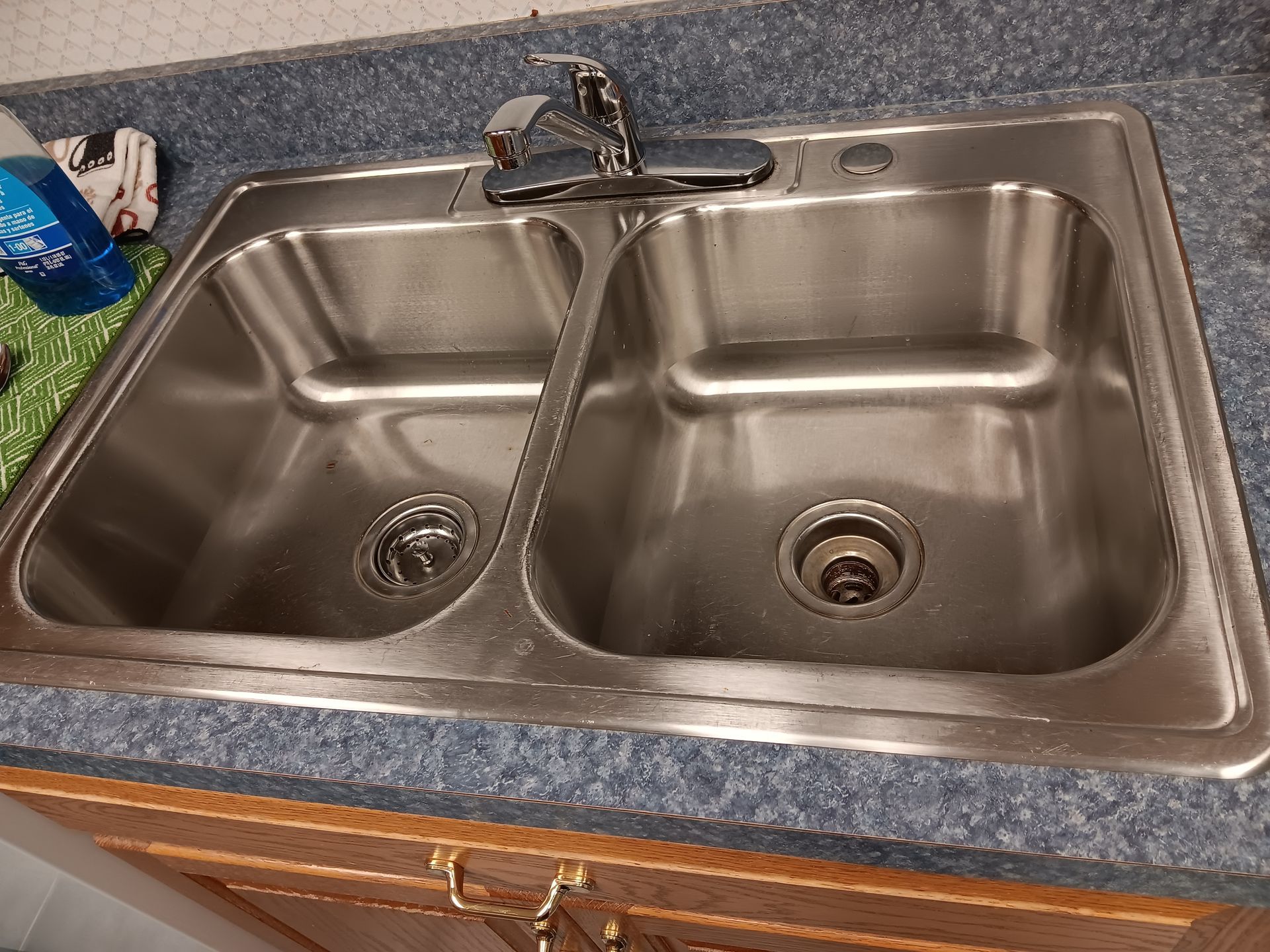 A stainless steel kitchen sink with two sinks and a faucet