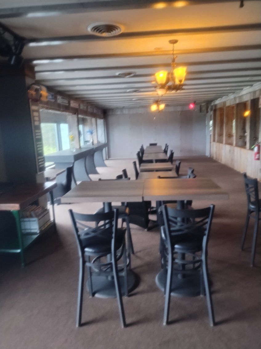 A long room with tables and chairs in it