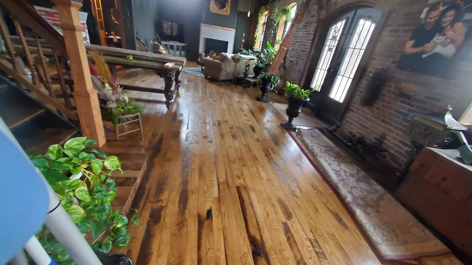 A living room with hardwood floors and a brick wall.
